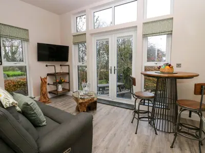 a living room with a couch and a table at Elderflower Lodge in Grange Over Sands