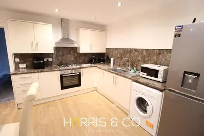 a kitchen with white cabinets and a washer and dryer at Fishermans Rest in Fleetwood