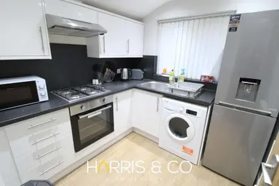 a kitchen with white cabinets and a washer and dryer at Fishermans View in Fleetwood