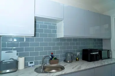 a kitchen counter with a sink and blue tiles at Sleek Apartment in Blackpool, Beach View, WiFi, Sleeps 6 in Blackpool