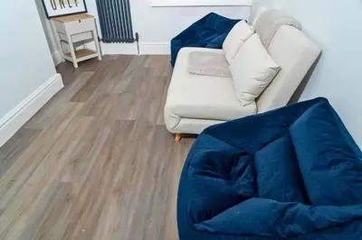 a living room with a couch and a chair at Sleek Apartment in Blackpool, Beach View, WiFi, Sleeps 6 in Blackpool