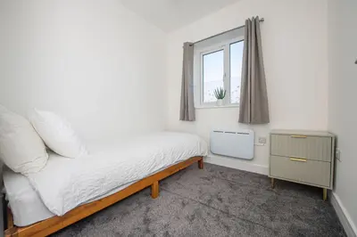 a small bedroom with a bed and a window at Modern 3-Bed Home-Liverpool Stay in Sefton