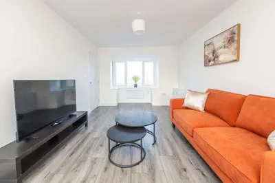 a living room with a orange couch and a table at Modern 3-Bed Home-Liverpool Stay in Sefton