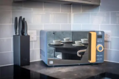 a miniature kitchen with coffee cups in a toaster oven at Modern 3-Bed Home-Liverpool Stay in Sefton