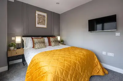 a bedroom with a large bed with a yellow blanket at Stunning Liverpool Dockside Apt by City SuperHost in Liverpool