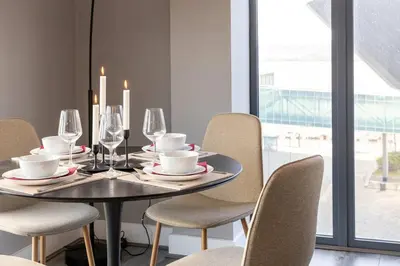 a dining room with a table with chairs and a window at Stunning Liverpool Dockside Apt by City SuperHost in Liverpool