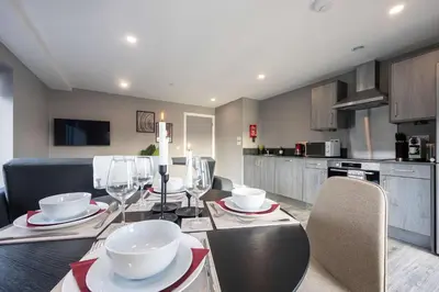 a kitchen with a dining table with wine glasses at Stunning Liverpool Dockside Apt by City SuperHost in Liverpool