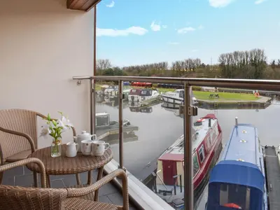 a balcony with a table and a view of a marina at Sailing By in Carnforth