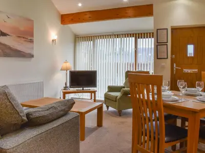 a living room with a couch and a table at Sandpiper in Carnforth