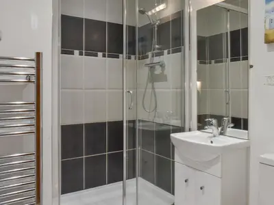 a bathroom with a shower and a sink at Sandpiper in Carnforth