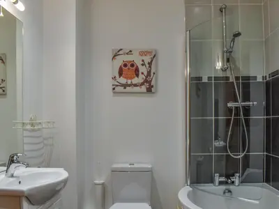 a bathroom with a shower and a toilet and a sink at Sandpiper in Carnforth