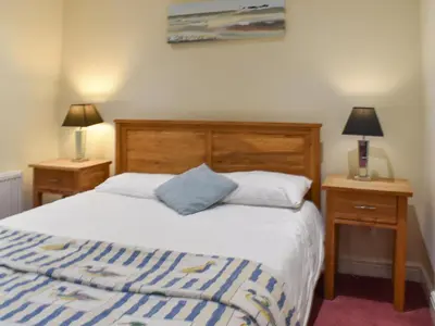 a bedroom with a bed and two night stands with lamps at Sandpiper in Carnforth