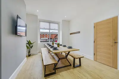 a dining room with a wooden table and benches at Lund House in Ulverston