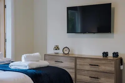 a bedroom with a dresser with a tv on the wall at Lund House in Ulverston