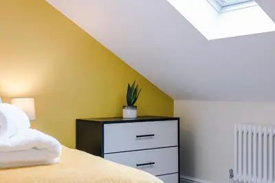 a bedroom with a bed and a dresser with a plant on it at Lund House in Ulverston