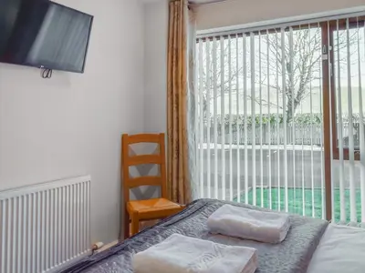 a bedroom with a bed and a large window at Waterside Retreat in Carnforth