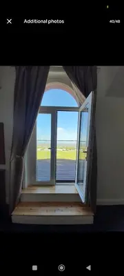 an open window with a view of an airport at Comfortable family home with amazing Seaviews in Fleetwood