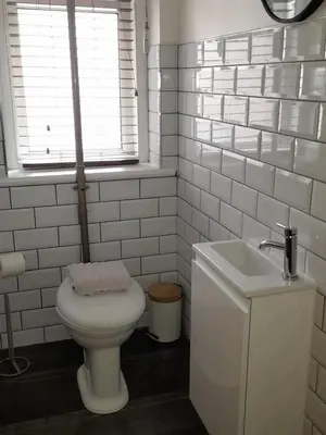 a white bathroom with a toilet and a sink at Comfortable family home with amazing Seaviews in Fleetwood