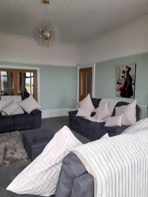 a living room with two couches and a bed at Comfortable family home with amazing Seaviews in Fleetwood
