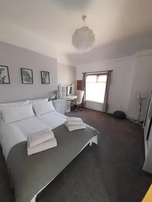 a bedroom with a large bed with two towels on it at Comfortable family home with amazing Seaviews in Fleetwood