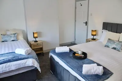 a bedroom with two beds with towels and a bowl of fruit at Cosy 2-Bed Home Near St Helens Centre - Free WiFi in Saint Helens
