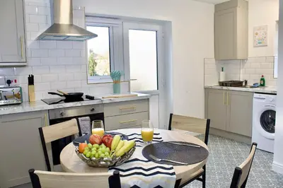 a kitchen with a table with a bowl of fruit on it at Cosy 2-Bed Home Near St Helens Centre - Free WiFi in Saint Helens