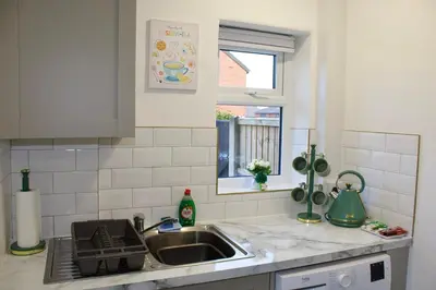 a kitchen counter with a sink and a window at Cosy 2-Bed Home Near St Helens Centre - Free WiFi in Saint Helens