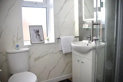 a white bathroom with a toilet and a sink at Cosy 2-Bed Home Near St Helens Centre - Free WiFi in Saint Helens