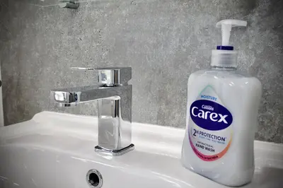 a bottle of soap sitting on top of a bathroom sink at Cosy 2-Bed Home Near St Helens Centre - Free WiFi in Saint Helens