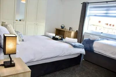 a bedroom with two beds and a window at Cosy 2-Bed Home Near St Helens Centre - Free WiFi in Saint Helens