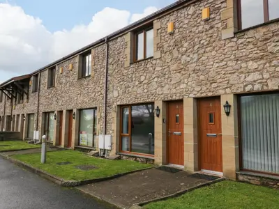 a brick building with brown doors and windows at 9 Swan House in Carnforth