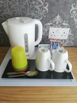 a tray with two cups and two mugs on it at Camelot Seafront Hotel in Blackpool
