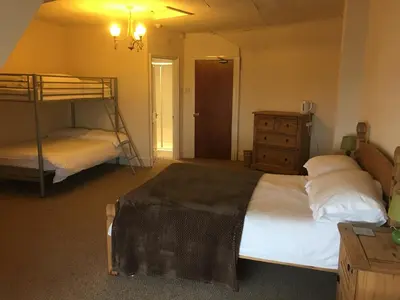 a bedroom with two bunk beds and a dresser at Camelot Seafront Hotel in Blackpool