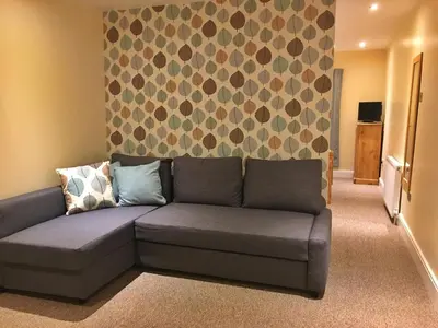 a couch in a living room with a wall at Camelot Seafront Hotel in Blackpool