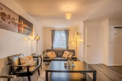 a living room with a couch and a table at 5-Beds in Quiet Three Bedroom House Near Anfield Stadium, free Parking in Liverpool