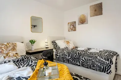 a living room with two beds and a mirror at 5-Beds in Quiet Three Bedroom House Near Anfield Stadium, free Parking in Liverpool