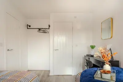 a bedroom with a bed and a table and a mirror at 5-Beds in Quiet Three Bedroom House Near Anfield Stadium, free Parking in Liverpool