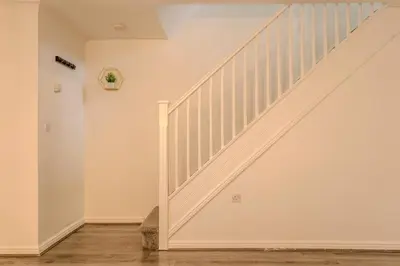 a staircase in a home with white walls and wooden floors at 5-Beds in Quiet Three Bedroom House Near Anfield Stadium, free Parking in Liverpool
