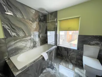 a bathroom with a bath tub and a toilet at Serenity Holiday Apartments in Blackpool