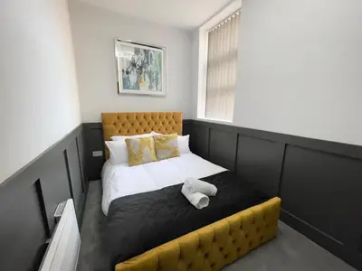 a bedroom with a bed with a teddy bear on it at Serenity Holiday Apartments in Blackpool