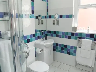 a bathroom with a toilet and a sink and a shower at FourRooms - Couples Only in Blackpool