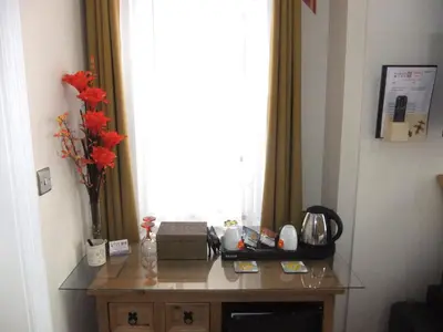 a table in a room with a window with flowers on it at FourRooms - Couples Only in Blackpool
