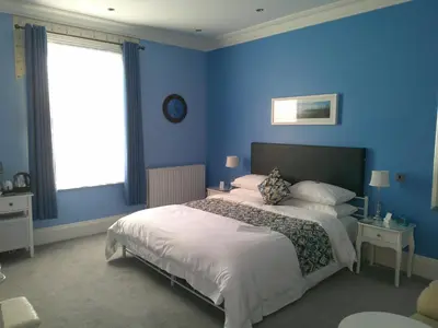 a bedroom with blue walls and a large bed at FourRooms - Couples Only in Blackpool