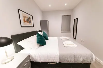 a bedroom with a large bed with green pillows at Convenient 2 Bed Apartment in Waterloo Liverpool in Waterloo