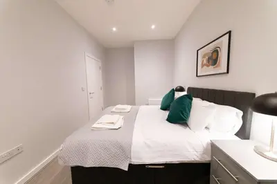 a bedroom with a bed with white and green pillows at Convenient 2 Bed Apartment in Waterloo Liverpool in Waterloo