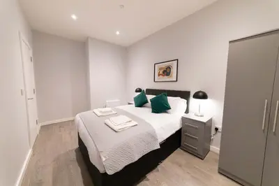 a bedroom with a large bed with green pillows at Convenient 2 Bed Apartment in Waterloo Liverpool in Waterloo