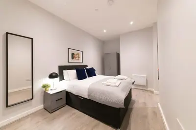 a bedroom with a large bed and a large mirror at Convenient 2 Bed Apartment in Waterloo Liverpool in Waterloo