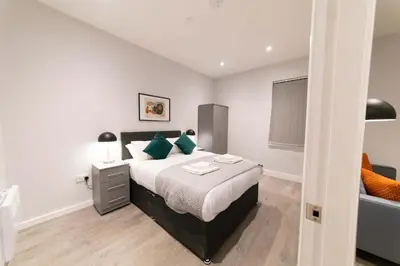 a bedroom with a large bed with green pillows at Convenient 2 Bed Apartment in Waterloo Liverpool in Waterloo