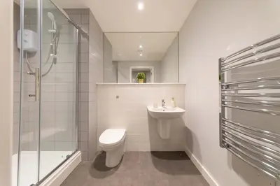 a bathroom with a toilet and a shower and a sink at Convenient 2 Bed Apartment in Waterloo Liverpool in Waterloo