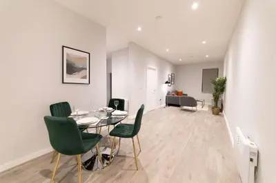 a dining room with a table and green chairs at Convenient 2 Bed Apartment in Waterloo Liverpool in Waterloo